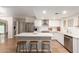 Bright kitchen features white cabinets, an island with seating, and stainless steel appliances at 6869 E Flossmoor Ave, Mesa, AZ 85208