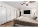 Well-lit main bedroom features a ceiling fan and built-in storage, complemented by wood flooring at 6869 E Flossmoor Ave, Mesa, AZ 85208