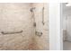 Shower stall featuring tile walls, shower head, and grab bars for added safety and accessibility at 6869 E Flossmoor Ave, Mesa, AZ 85208