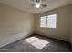 Bedroom with tan walls, carpet, a ceiling fan and window creating a sunlit space at 7922 W Alex Ave, Peoria, AZ 85382