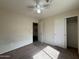 Bedroom featuring neutral walls, carpet, ceiling fan, with view to closet and hallway at 7922 W Alex Ave, Peoria, AZ 85382