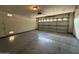 Empty two car garage with a standard white garage door and door to inside the house at 7922 W Alex Ave, Peoria, AZ 85382