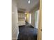 Entry hallway with dark tile, white cabinets, and access to multiple rooms within the house at 7922 W Alex Ave, Peoria, AZ 85382