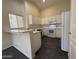 Bright kitchen features white cabinets, appliances, breakfast bar and dark tile flooring at 7922 W Alex Ave, Peoria, AZ 85382