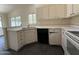 Kitchen sink and countertop with black dishwasher and light cabinets with dark handles at 7922 W Alex Ave, Peoria, AZ 85382
