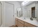 Bathroom featuring a wide mirror and sink with wood cabinets and an adjacent closet with shelving at 7950 E Keats Ave # 175, Mesa, AZ 85209