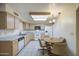 Well-lit kitchen featuring a breakfast table, white appliances and light wood cabinetry at 7950 E Keats Ave # 175, Mesa, AZ 85209