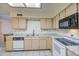 Bright kitchen with white appliances, light wood cabinets and neutral tile flooring at 7950 E Keats Ave # 175, Mesa, AZ 85209
