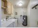 Laundry room with a washer, dryer, sink, and water heater, offering functionality and convenience at 7950 E Keats Ave # 175, Mesa, AZ 85209