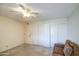 Carpeted room with sofa and lamp featuring multiple closets and a door with a ceiling fan at 7950 E Keats Ave # 175, Mesa, AZ 85209