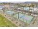 Aerial view of community pickle ball courts, palm trees, and community pool for active recreation at 8149 E Petunia Ave # 1042, Mesa, AZ 85212