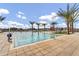Resort-style community pool featuring a splash pad with surrounding palm trees and comfortable lounge chairs at 8154 E Petra Ave, Mesa, AZ 85212