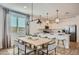 Bright dining area with modern lighting, adjacent to a stylish kitchen with counter seating and stainless steel appliances at 8154 E Petra Ave, Mesa, AZ 85212