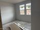 Unfinished bedroom featuring drywall and natural light from two windows at 9536 W Parkway Dr, Tolleson, AZ 85353