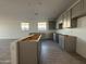 Spacious kitchen with gray cabinets and natural light from the windows at 9536 W Parkway Dr, Tolleson, AZ 85353
