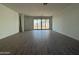 Spacious living room boasts wood-look tile and sliding glass doors to backyard at 9536 W Parkway Dr, Tolleson, AZ 85353