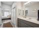 Neutral primary bathroom with gray cabinets, a large mirror, and a view to the main bedroom at 9600 N 96 Th St # 130, Scottsdale, AZ 85258