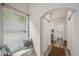 Bright hallway featuring a window seat, an arched doorway, and wood-look floors at 9600 N 96 Th St # 130, Scottsdale, AZ 85258