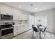 Clean kitchen with white cabinets, stainless steel appliances, and an adjacent dining area with natural light at 9600 N 96 Th St # 130, Scottsdale, AZ 85258