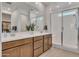 Well-lit bathroom featuring double sink vanity, quartz countertops, and a glass-enclosed shower at 9630 W Atlantis Way, Tolleson, AZ 85353
