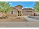 Single-story home showcases a two-car garage and a xeriscaped front yard, blending style and sustainability at 9630 W Atlantis Way, Tolleson, AZ 85353