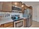 Kitchen with stainless steel appliances, wooden cabinets, gas range, and a pot filler faucet at 9630 W Atlantis Way, Tolleson, AZ 85353