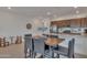 Beautiful kitchen with stainless steel appliances and hardwood dining table with black chairs at 9630 W Atlantis Way, Tolleson, AZ 85353