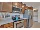 Kitchen with stainless steel appliances, wooden cabinets, gas range, and a pot filler faucet at 9630 W Atlantis Way, Tolleson, AZ 85353