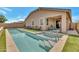 Inviting backyard pool with a spa, artificial grass, and covered patio seating area at 9630 W Atlantis Way, Tolleson, AZ 85353