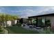 Landscaped backyard with a well-maintained lawn, desert plants, a modern home with glass walls and patio furniture at 0 N 128Th St, Scottsdale, AZ 85255