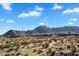 Rolling desert landscape with scattered vegetation and homes leading up to rugged mountain peaks at 0 N 128Th St, Scottsdale, AZ 85255