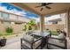 Stylish covered back patio features a cozy seating area with a fire pit table at 10050 E Texas Ave, Mesa, AZ 85212
