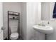 This half bathroom includes a pedestal sink, decorative shelving, and a clean, minimalist aesthetic at 10050 E Texas Ave, Mesa, AZ 85212