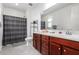 Well-lit bathroom with cherry cabinets, white counter, and a shower-tub combo at 10050 E Texas Ave, Mesa, AZ 85212