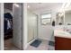 Bathroom featuring a walk-in shower, double sink vanity, walk-in closet, and ample lighting at 10050 E Texas Ave, Mesa, AZ 85212