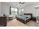 Bright bedroom with ceiling fan, neutral carpet, under-bed storage and large window with neighborhood views at 10050 E Texas Ave, Mesa, AZ 85212