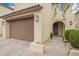 Beautiful tan home with a tile roof, desert landscaping, and a two-car brown garage door at 10050 E Texas Ave, Mesa, AZ 85212