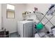 Well-lit laundry room with a washer, dryer, and storage shelving at 10050 E Texas Ave, Mesa, AZ 85212