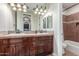 Bathroom with dual sinks, wooden vanity and a bathtub at 1022 W Calypso Ct, Gilbert, AZ 85233