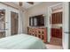 A spacious bedroom with a ceiling fan, TV and doorway leading to additional rooms at 1022 W Calypso Ct, Gilbert, AZ 85233
