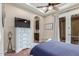 Comfortable bedroom with a ceiling fan, flat screen tv, and built-in storage at 1022 W Calypso Ct, Gilbert, AZ 85233