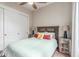 Comfortable bedroom featuring ceiling fan, a cozy bed with colorful pillows, and closet at 1022 W Calypso Ct, Gilbert, AZ 85233
