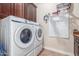 Bright laundry room with Samsung washer and dryer, storage, and hanging rack at 1022 W Calypso Ct, Gilbert, AZ 85233