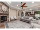 Spacious living room with stone fireplace, ceiling fan, and an open layout at 1022 W Calypso Ct, Gilbert, AZ 85233