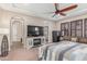 Open-concept main bedroom features a ceiling fan, fireplace, and flat screen television at 1022 W Calypso Ct, Gilbert, AZ 85233