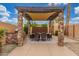 Outdoor dining area featuring a built-in stone grill, dining table under a pergola with shade at 1022 W Calypso Ct, Gilbert, AZ 85233