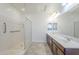 Bright bathroom featuring double sinks, a glass shower, and tile flooring at 10609 E Durant Dr, Mesa, AZ 85212