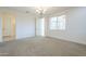 Bright bedroom with neutral carpet, a chandelier, and a large window at 10609 E Durant Dr, Mesa, AZ 85212