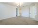 Carpeted room features a chandelier and bathroom access at 10609 E Durant Dr, Mesa, AZ 85212