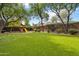 Expansive backyard with lush green turf, mature trees, and a fun play structure at 10892 E Gold Dust Ave, Scottsdale, AZ 85259